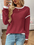 Women's loose round neck long sleeve polyester pullover top in light blue on a hanger.