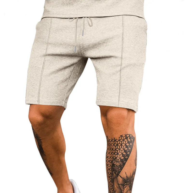 Solid colour polyester five-point sports shorts in Khaki, side view, showing elastic waist and above-knee length
