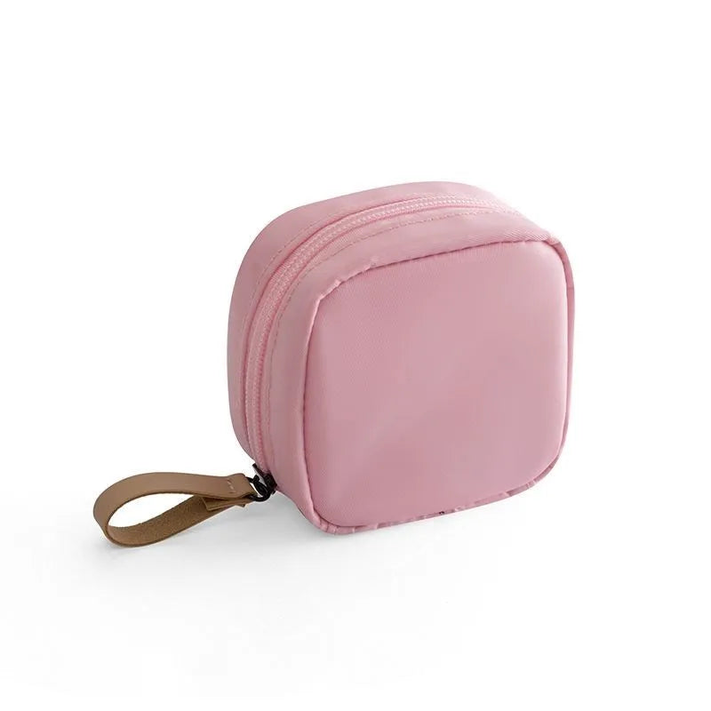 Blue cloth cube makeup storage bag with zipper open showing interior.