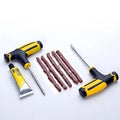 Black and yellow vacuum tyre repair tool set with probe, insertion tool, glue, and rubber strips on a table