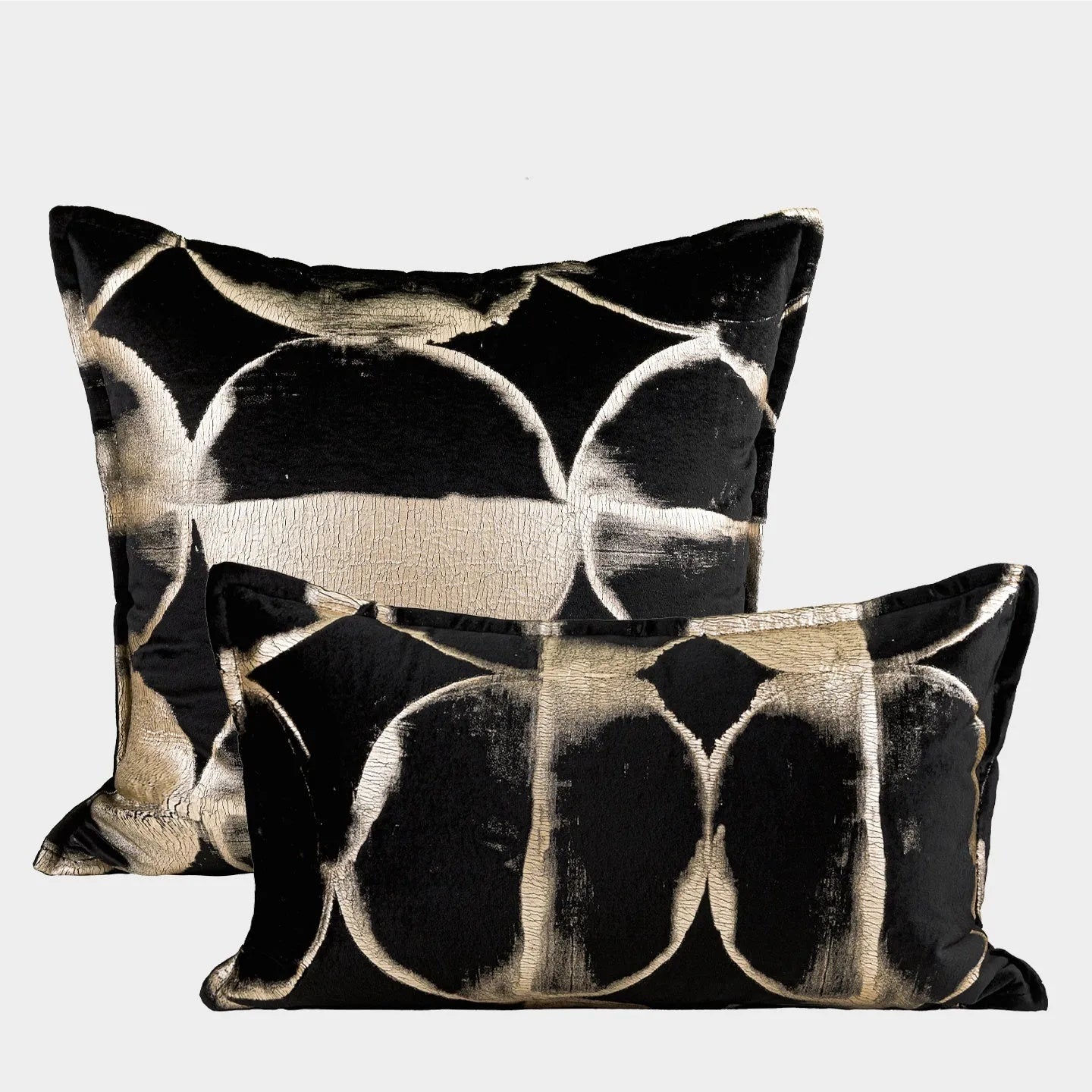 Black and gold abstract pattern decorative cushion cover on a grey sofa.