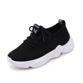 Women's white woven sports shoes with thick rubber sole and front strap.