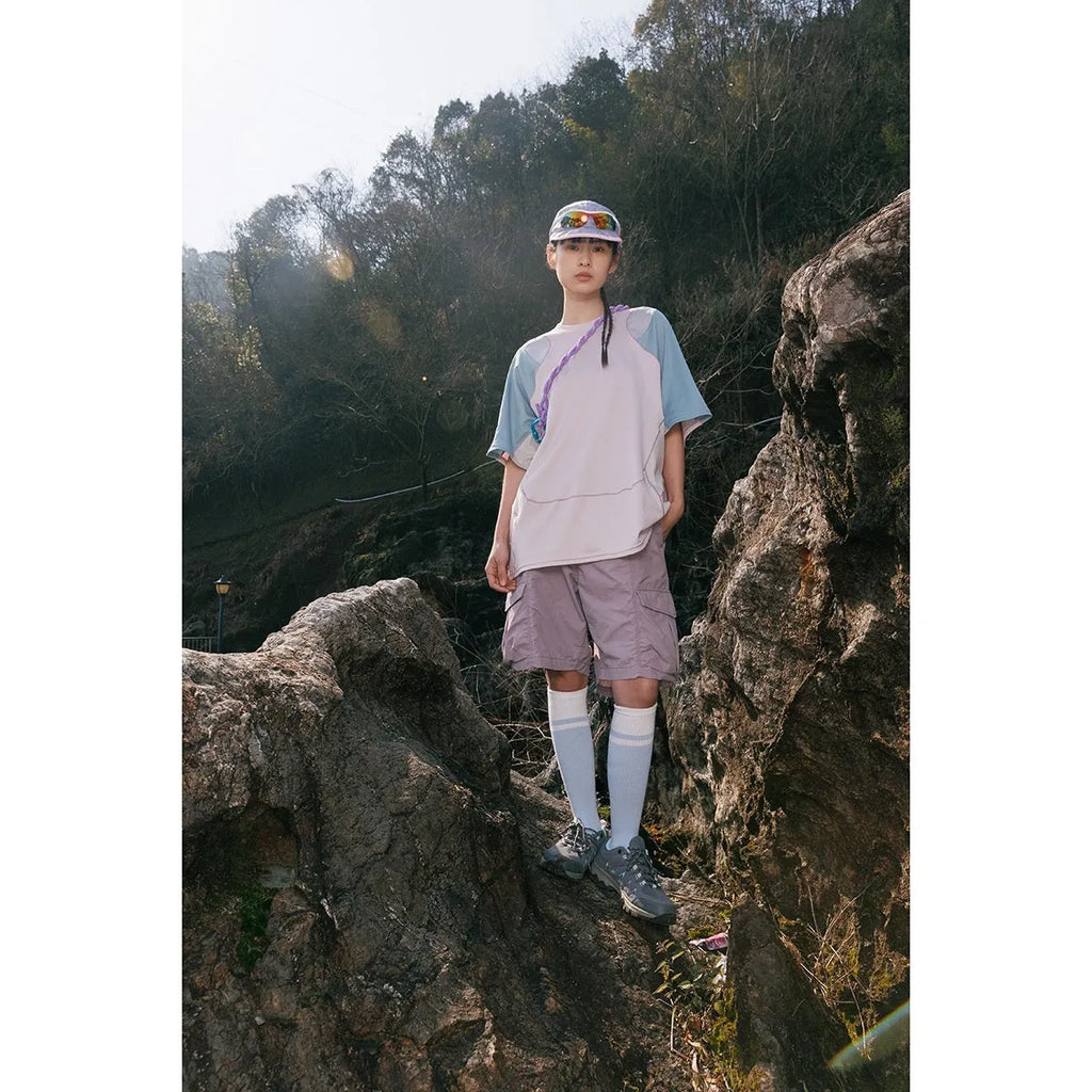 Men's loose blue patchwork short sleeve t-shirt on a hanger.
