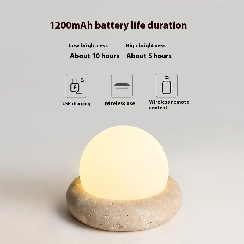 Cream coloured bedside night lamp with remote control on table