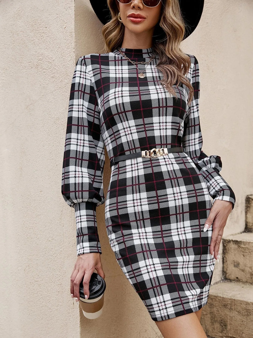 Black tight dress with voluminous lantern sleeves, leather stitching detail, and a printed pattern, mid-length skirt.