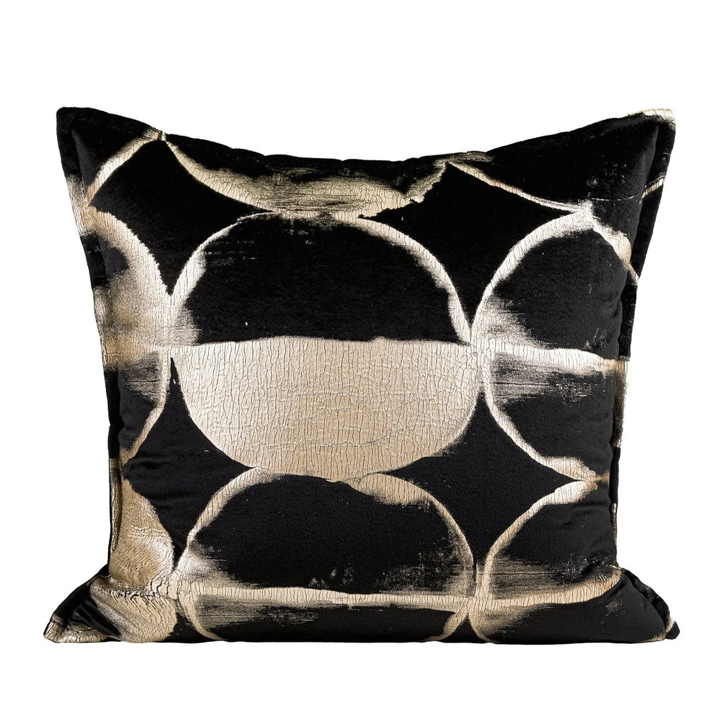 Black and gold abstract pattern decorative cushion cover on a grey sofa.