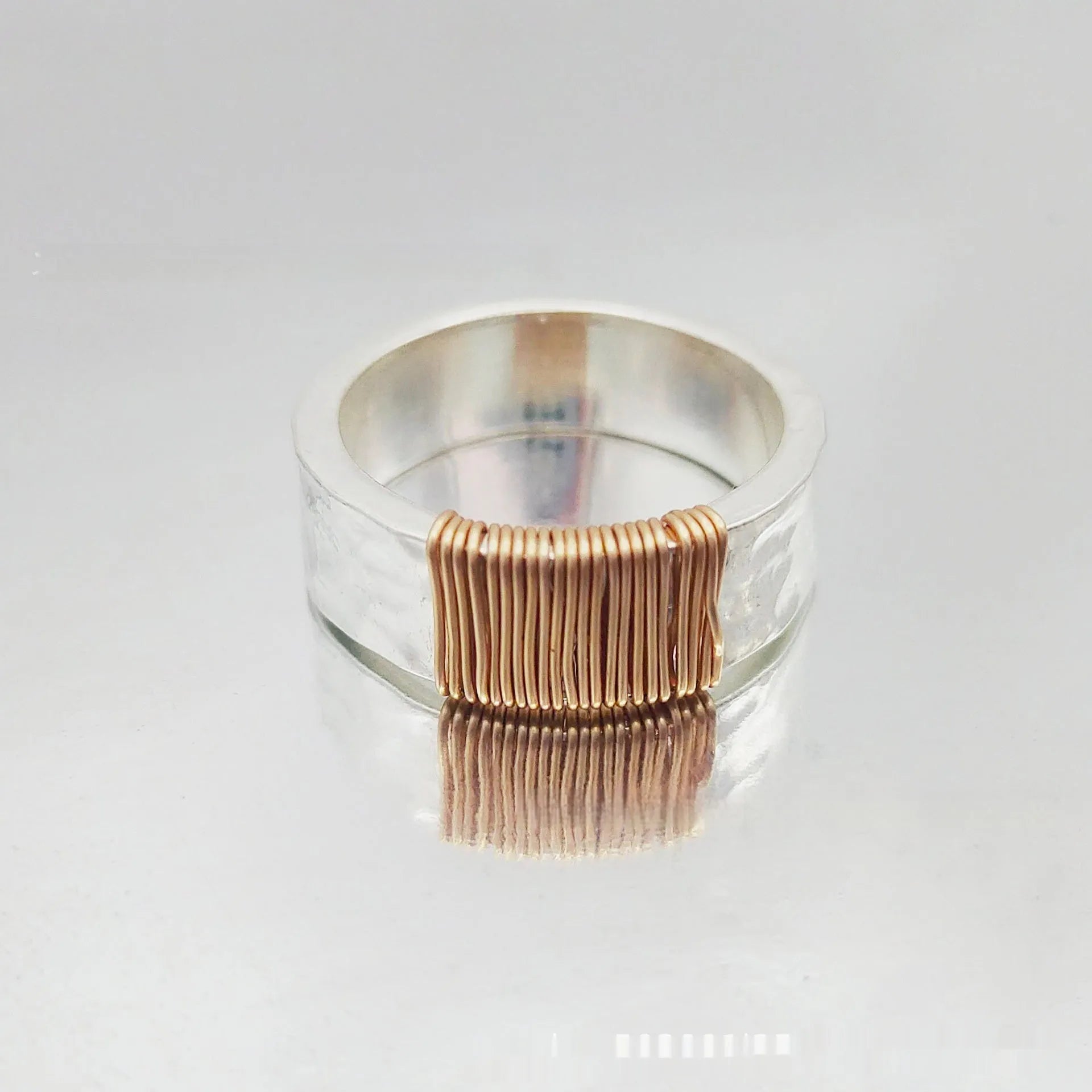 Simple geometric ring bracelet in electroplated copper with silver gold coil finish showing irregular coil design