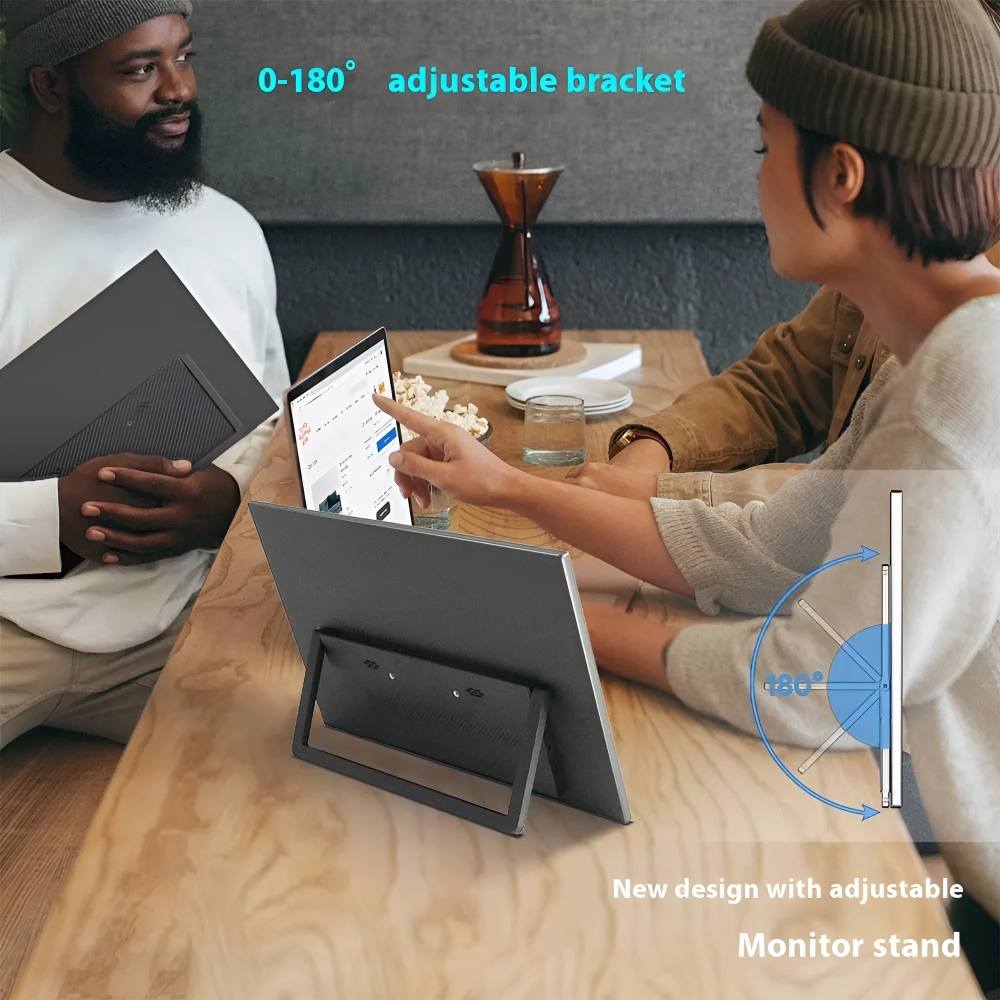15.6-inch black portable monitor with adjustable stand on a desk next to a laptop