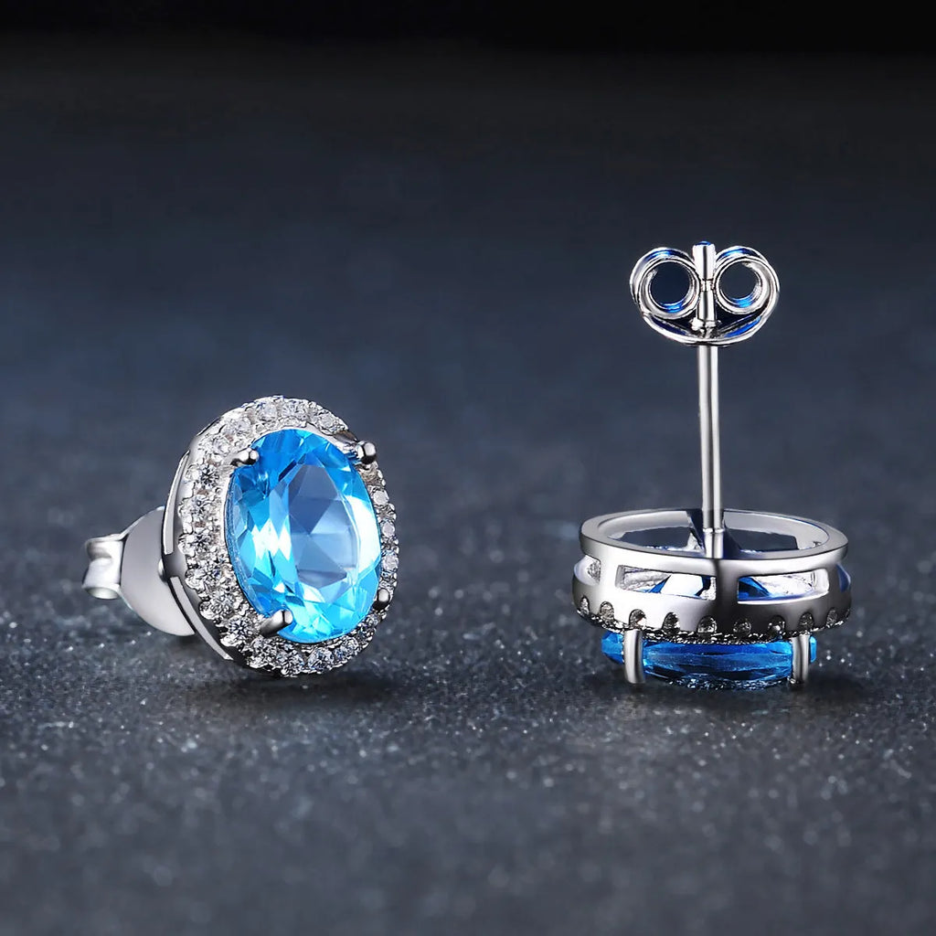 Geometric 925 sterling silver jewellery set with blue topaz stones, showing necklace, earrings, ring, and pendant.