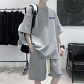 A man modelling a waffle-patterned grey short-sleeve top and matching shorts leisure set.