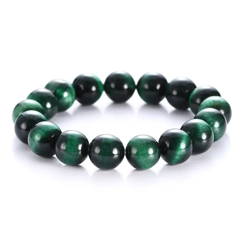 Green tiger eye stone bracelet with polished geometric beads on a wrist.