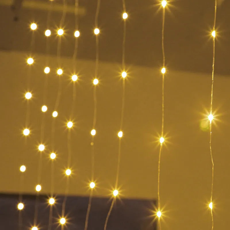 Copper curtain string light with 100 LED bulbs in blue, hung decoratively against a dark background.