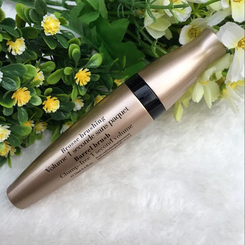 Gold tube black mascara in a vertical orientation against a light background