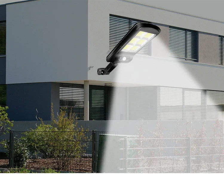 Black solar powered outdoor motion sensor light with solar panel for garden fence or driveway illumination