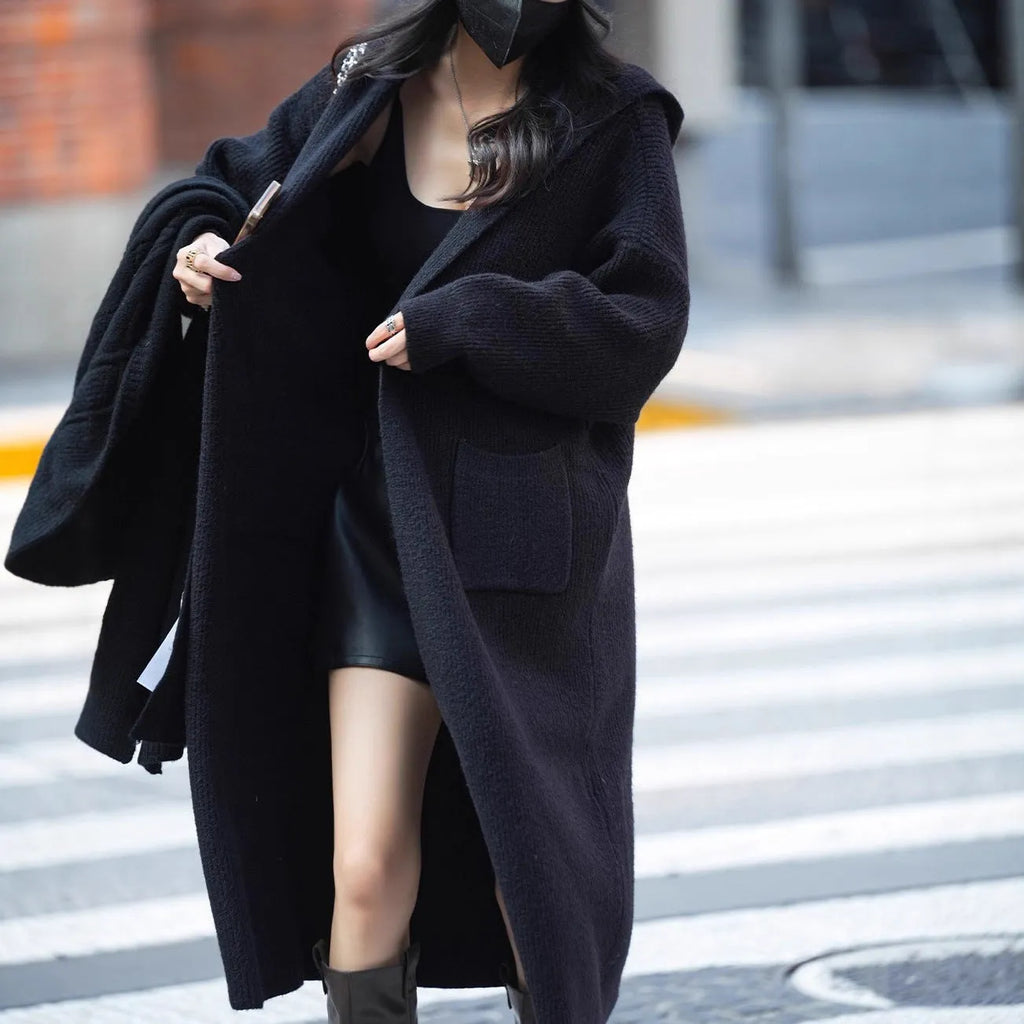 Long grey hooded knitted cardigan coat with trench coat style and loose fit.