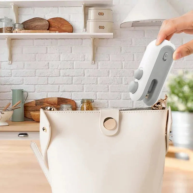 White and blue handheld USB rechargeable vacuum heat sealer with magnetic back