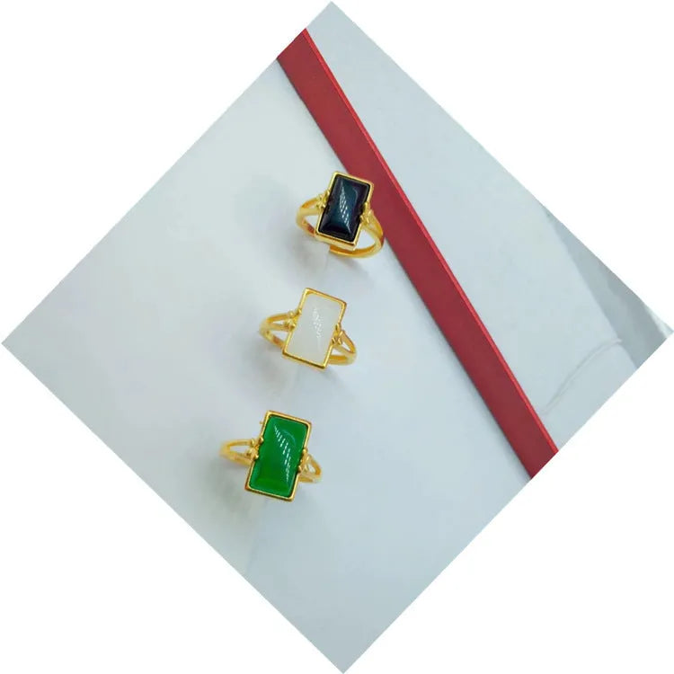 Adjustable gold-plated brass ring with a black gemstone inlay on a model's hand.