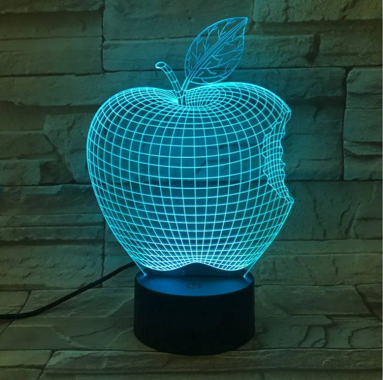 3D fruit-shaped colourful LED night light with touch control on a table.