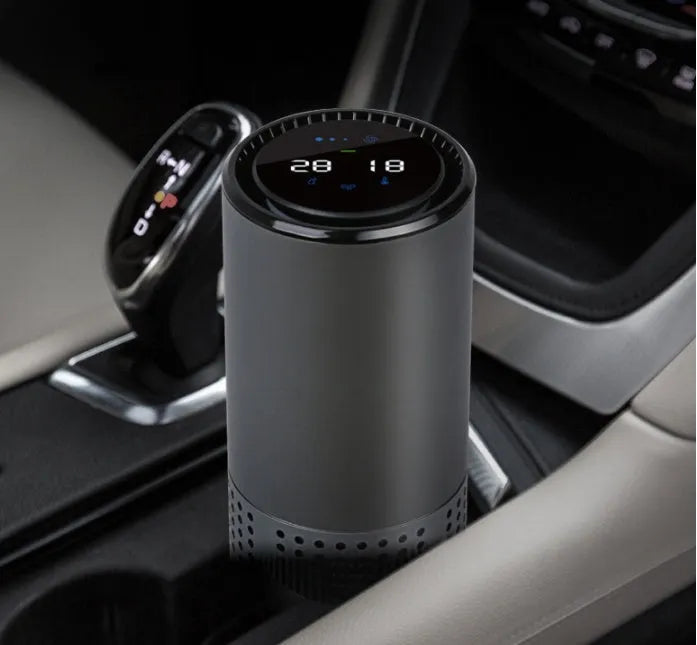 Aluminium alloy car air purifier with display screen showing air quality, placed on a car dashboard.