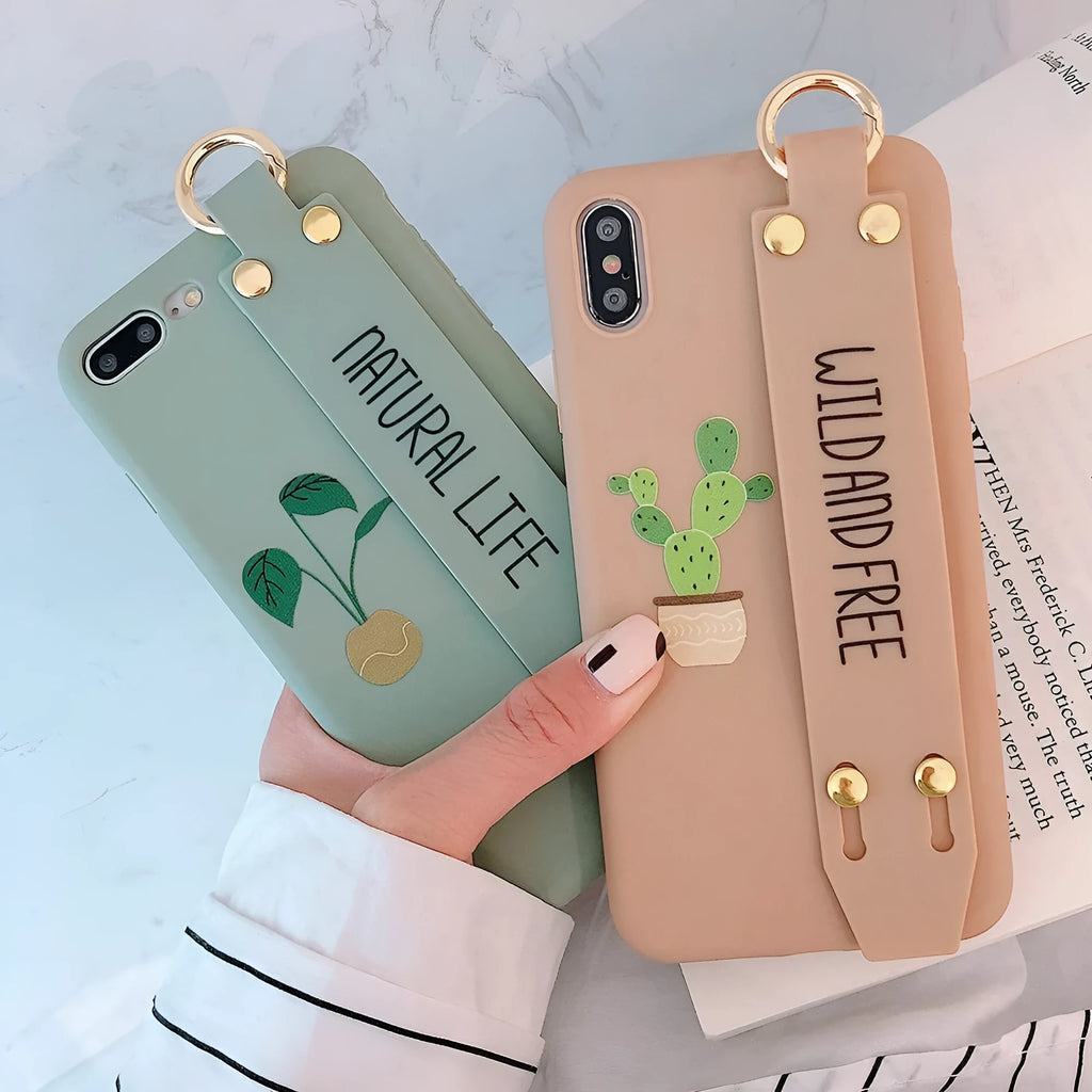 Green graffiti design iPhone case with a black detachable wrist strap looped around a hand.