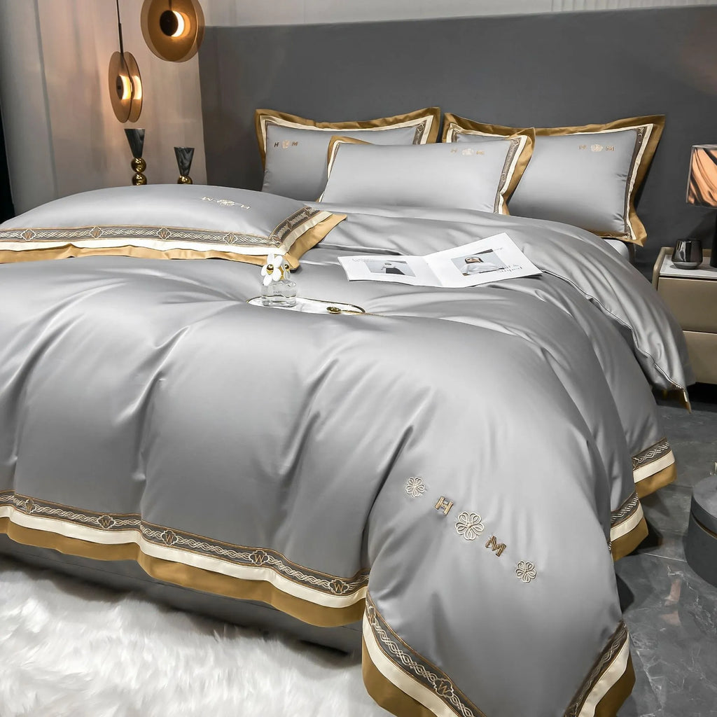 All-cotton light luxury four-piece bedding set with embroidery, available in multiple colours, on a bed