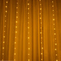 Copper curtain string light with 100 LED bulbs in blue, hung decoratively against a dark background.