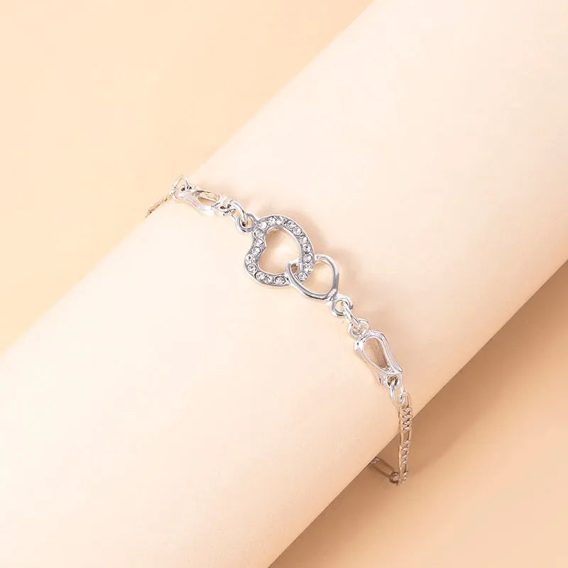 Silver romantic crystal heart jewelry set with bracelet necklace earrings on white background
