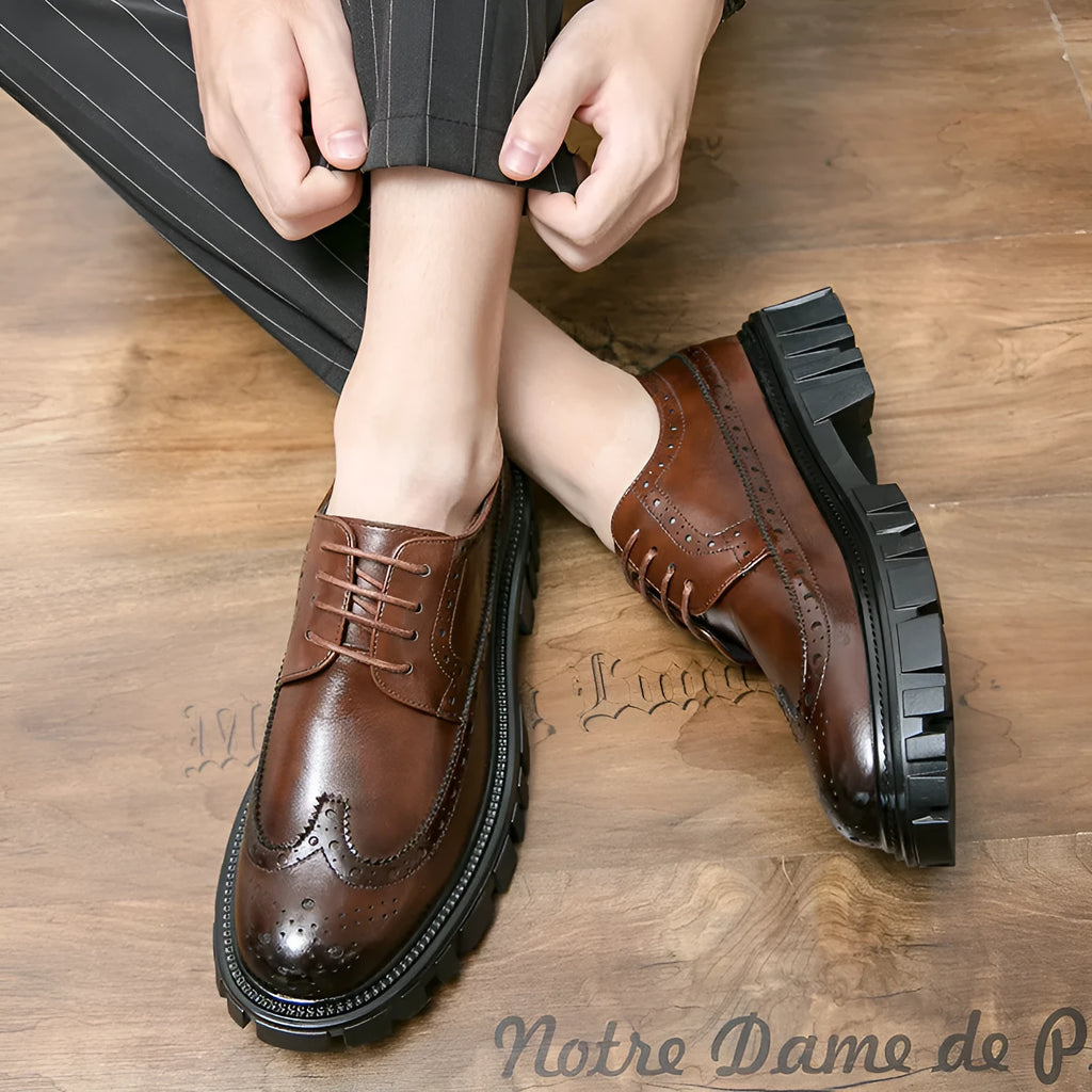 Men's black leather brogue shoes with round toe design on solid background