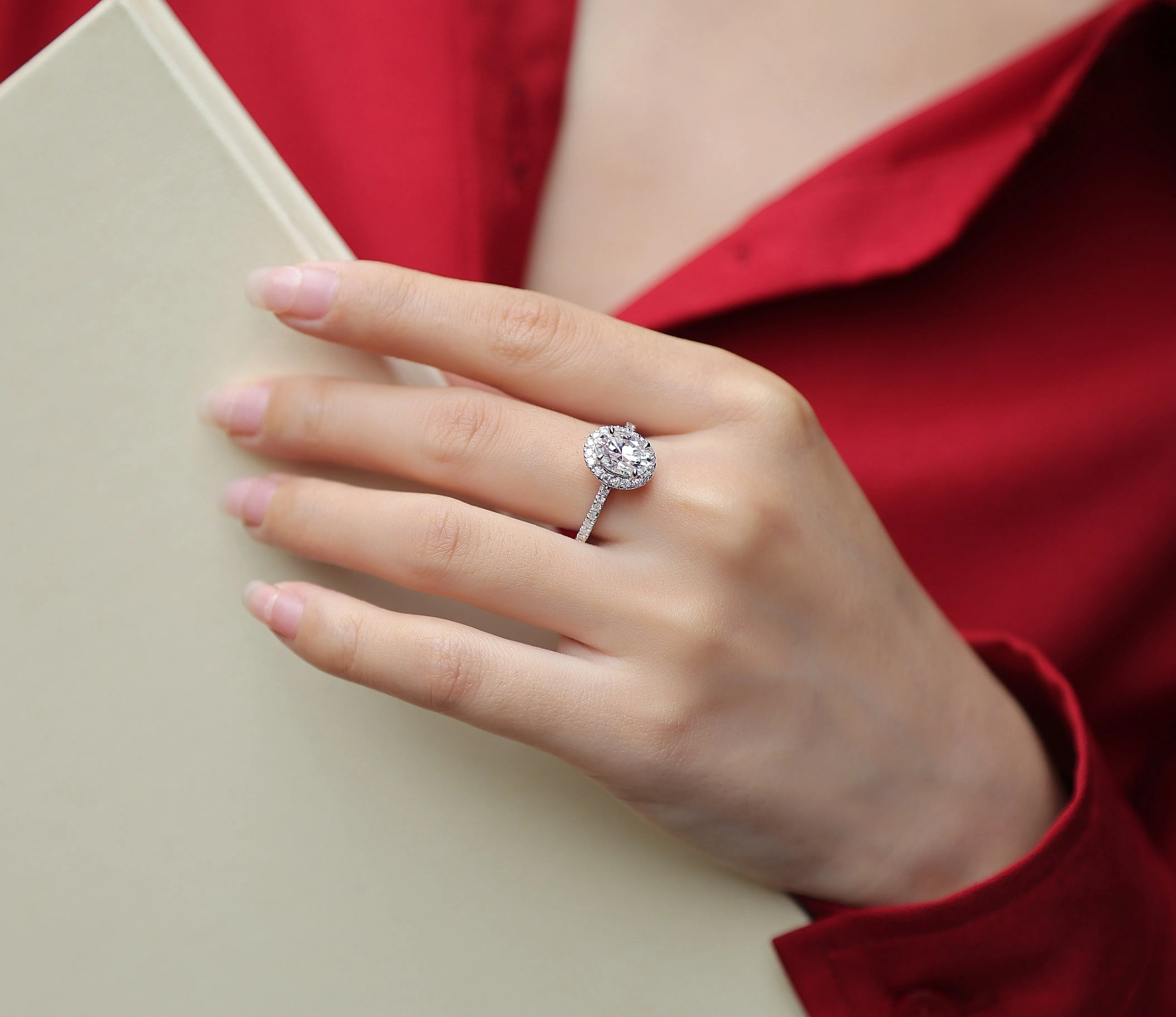 Egg-shaped 7x9mm moissanite wedding ring in S925 silver with platinum plating on white background