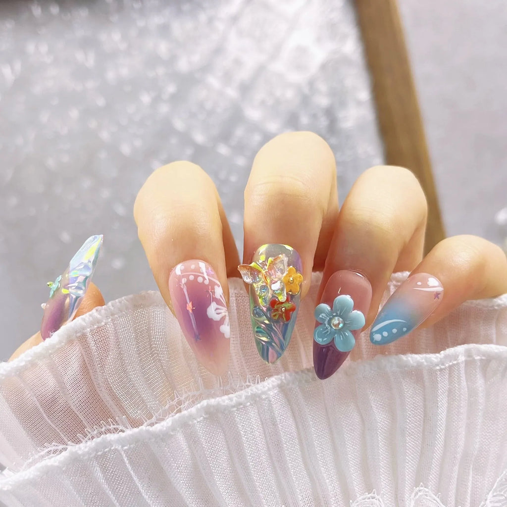Handmade nail art sculptures with embossed floral and butterfly patterns in almond shapes