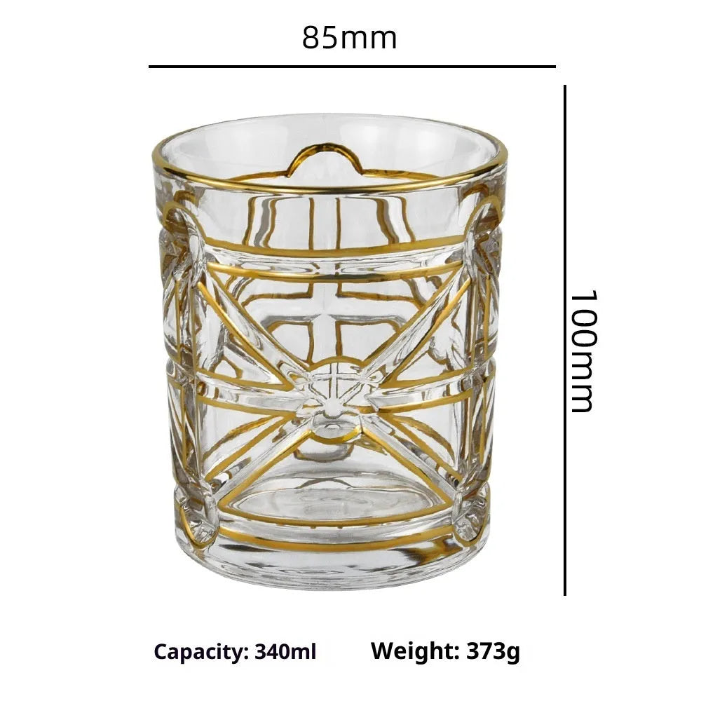 Crystal glass whiskey shot glass with solid gold finish on a bar counter