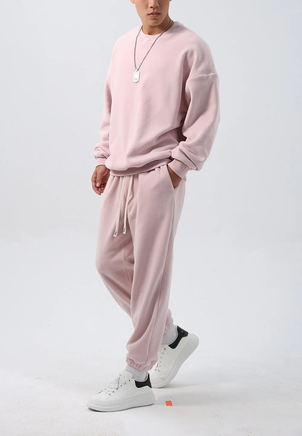 Men's black polar fleece sports suit with loose long sleeve coat and matching trousers on a hanger.
