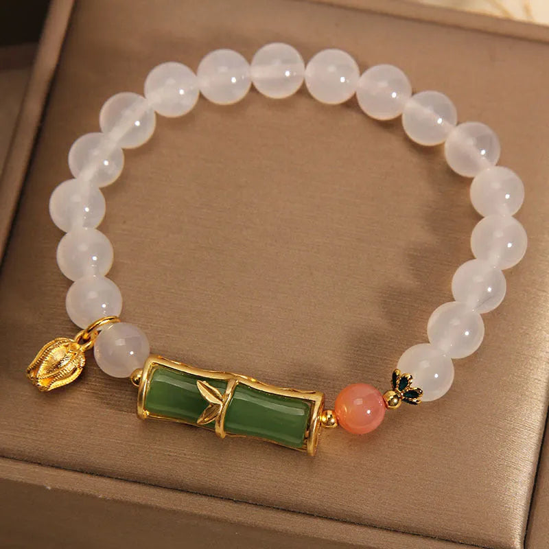 Women's white agate jade bracelet with bamboo joint design and a single bead centrepiece.
