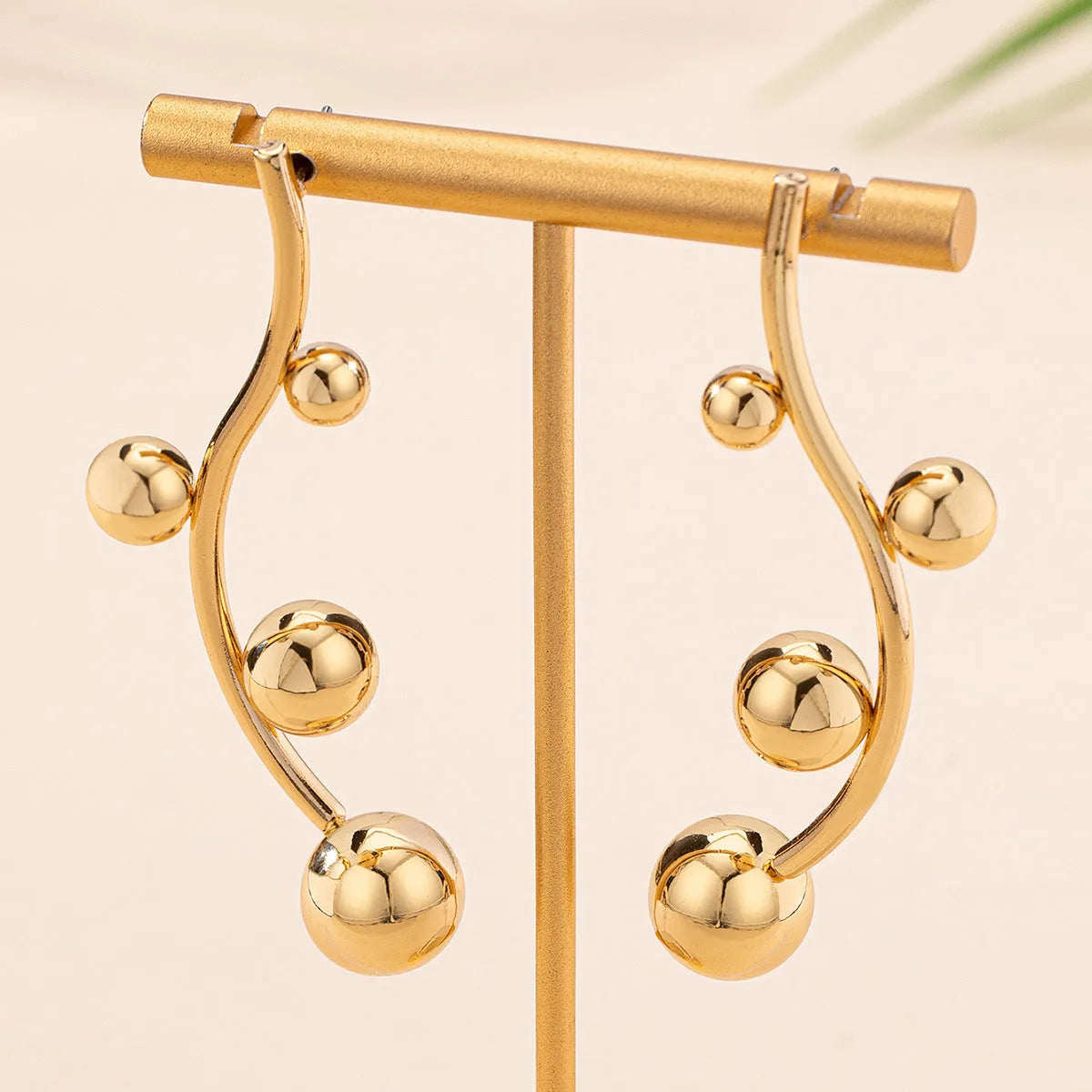 Golden yellow iron ball stud earrings with round shape on a white background