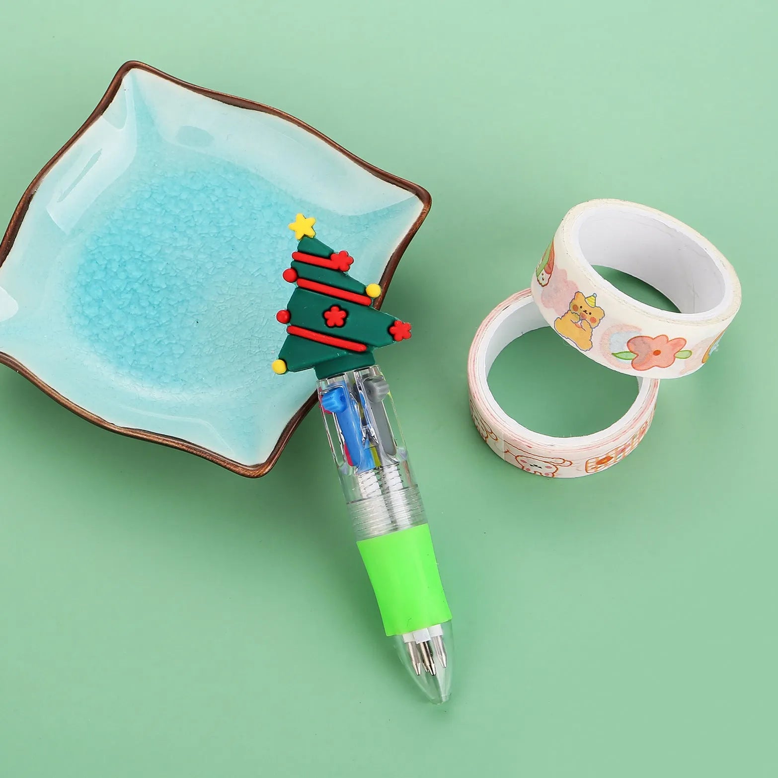 11cm long Christmas-themed four-colour ballpoint pen showing festive designs like reindeer and trees.