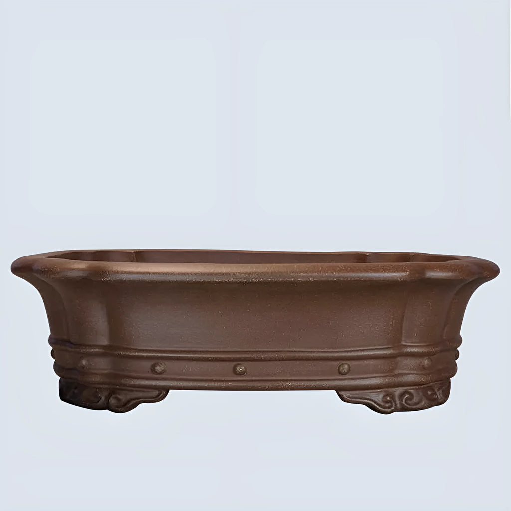 Purple clay handmade rectangular flower pot with antique design on wooden desktop
