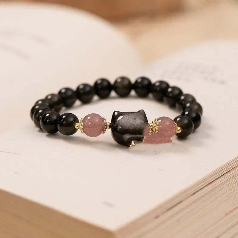 Single circle natural obsidian bracelet with 8mm black beads and kitty cat pendant on white background