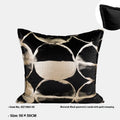Black and gold abstract pattern decorative cushion cover on a grey sofa.