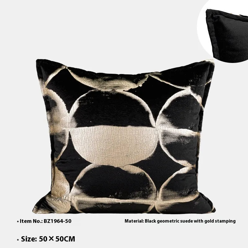 Black and gold abstract pattern decorative cushion cover on a grey sofa.