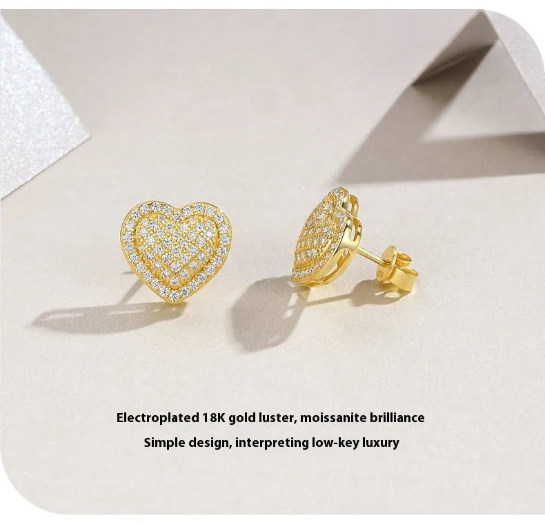 A pair of gold-toned heart-shaped stud earrings with a moissanite stone, made from S925 silver.
