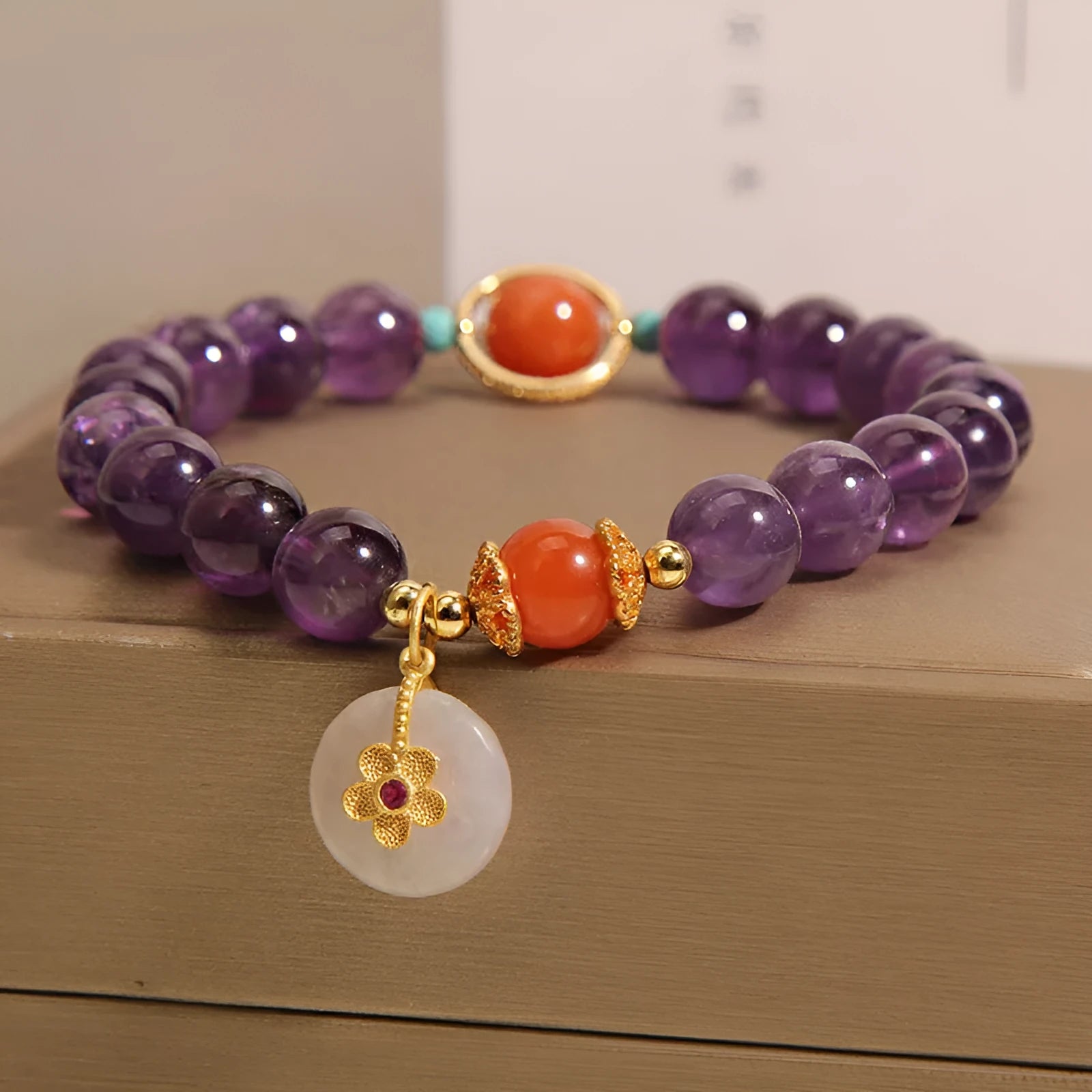Natural amethyst bracelet with sliding knot and small flower inlay on a white background