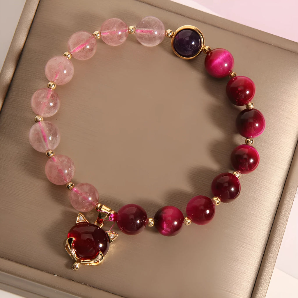 Simple women's bracelet with a strawberry crystal on a black elastic rope.