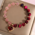 Simple women's bracelet with a strawberry crystal on a black elastic rope.