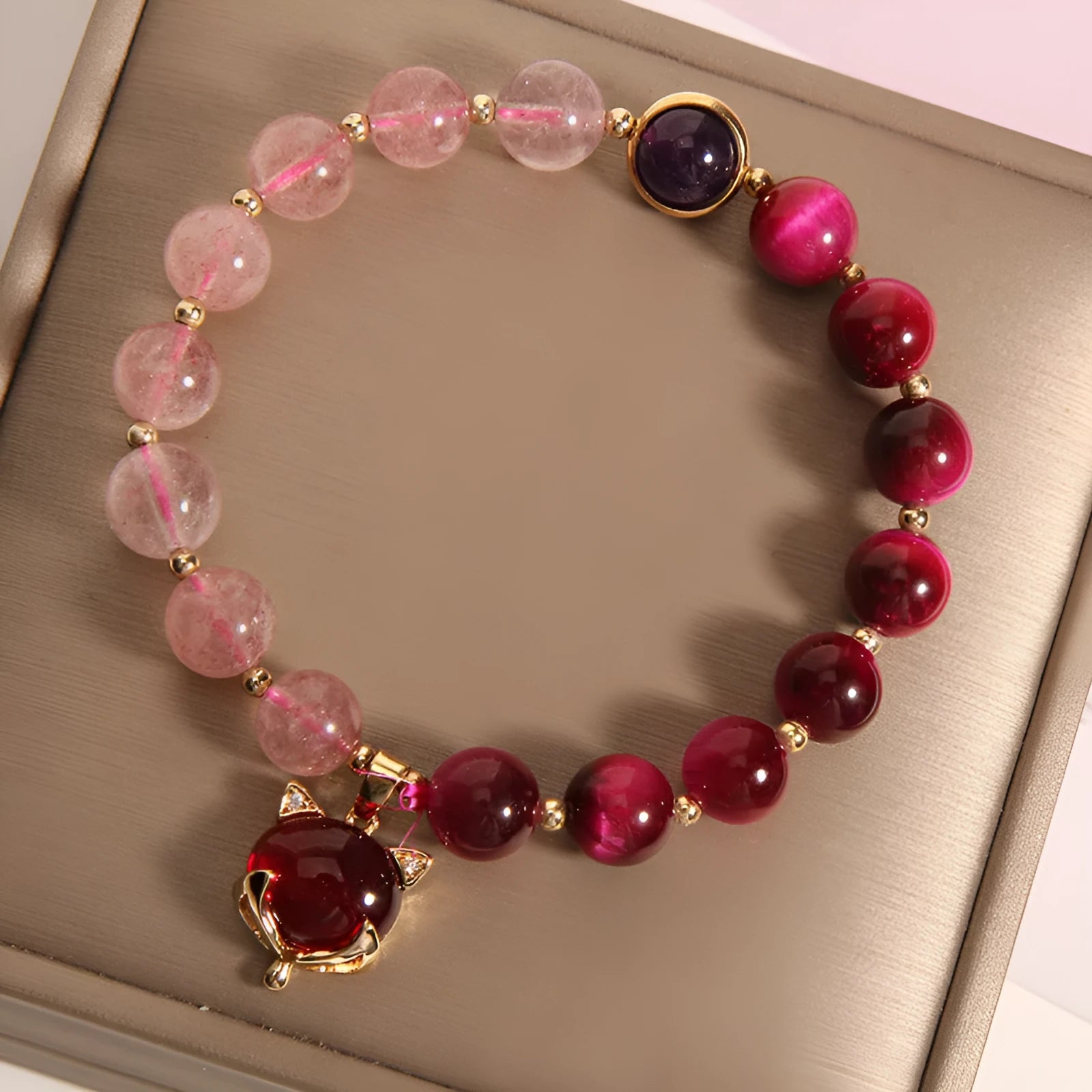 Simple women's bracelet with a strawberry crystal on a black elastic rope.