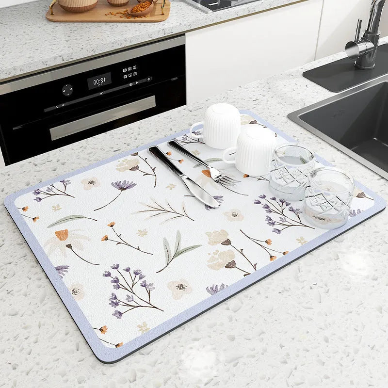 Square diatomite kitchen draining mat in camellia purple on a kitchen worktop, with a teacup resting on it