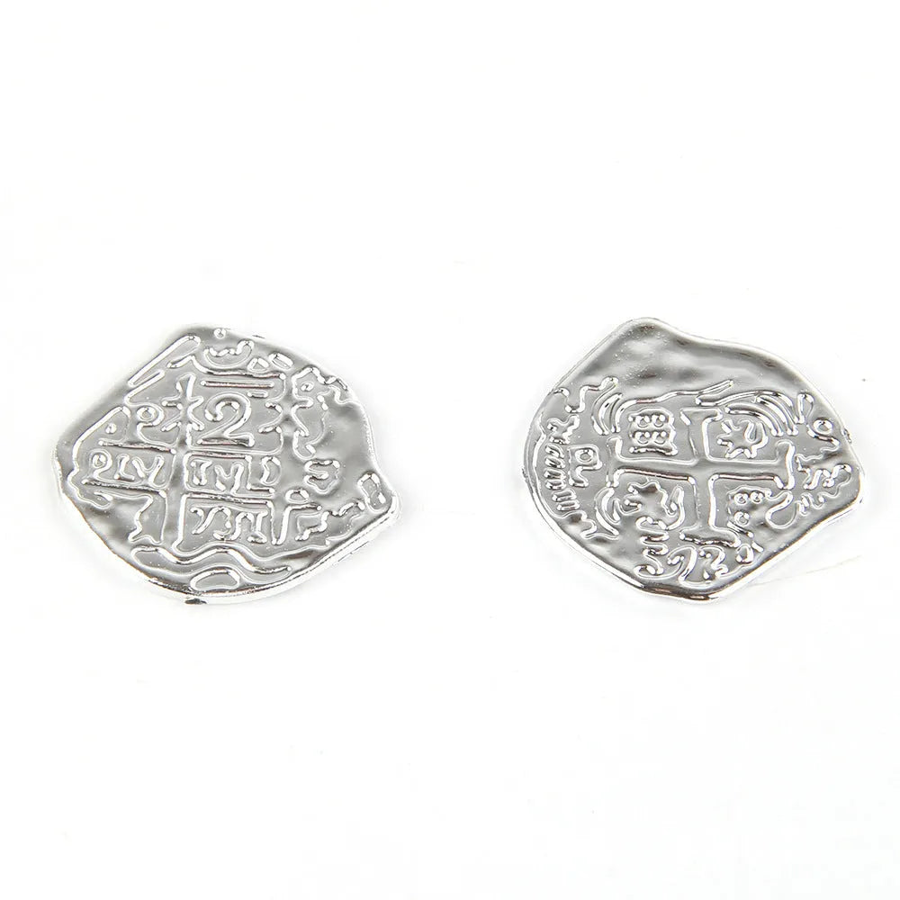 Close-up of detailed plastic Roman pirate coins in bronze, gold, and silver electroplated finishes.