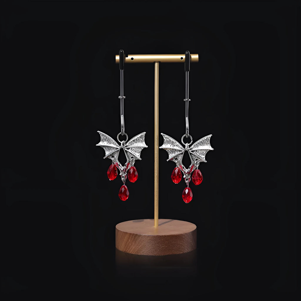 Silver bat-shaped nipple clamp with ruby accent detail and adjustable pressure mechanism