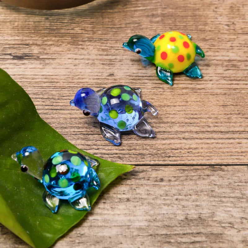 Geometric glass turtle ornament with blue head and blue shell on wooden surface