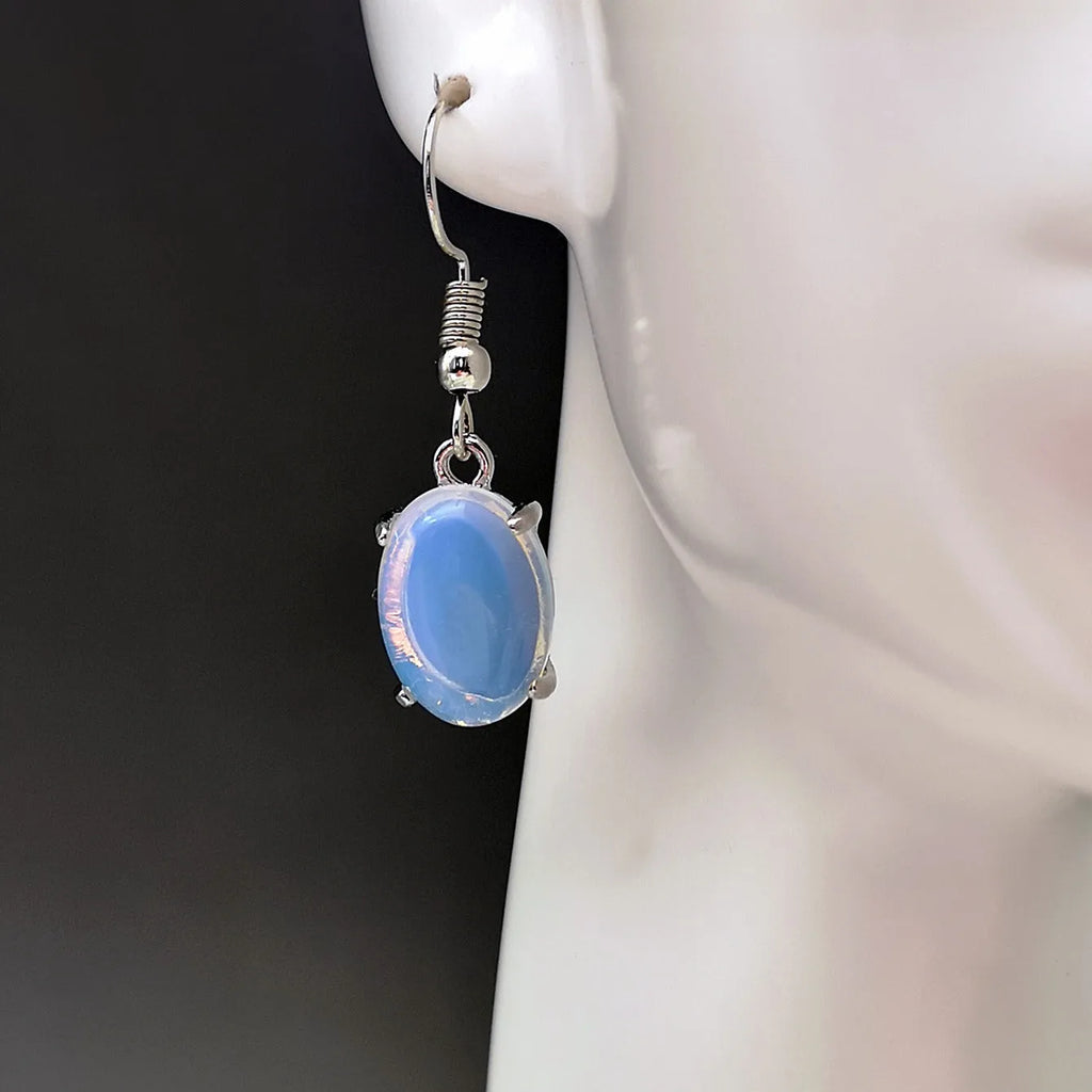 Pair of white retro-style drop earrings with a cross design and opal-like finish.