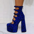 Women's black patent leather platform ankle boots with a thick heel and serpentine buckle fastening.